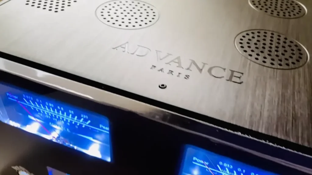 Advance Paris Xi 1100 front panel with dual blue VU meters, OPT1 input display, volume level reading 21.5, central aluminum volume knob, and input selector