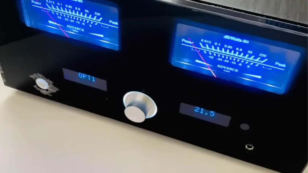 Close-up of the Advance Paris Xi 1100 machined aluminum volume knob with illuminated white ring and blue digital volume display showing 21.5