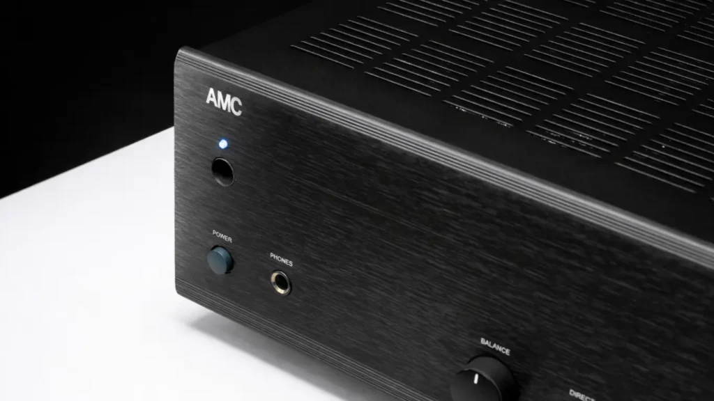 Angled close-up view of the AMC XIA150SE integrated amplifier, highlighting the AMC logo, power button, headphone jack, and top ventilation slots