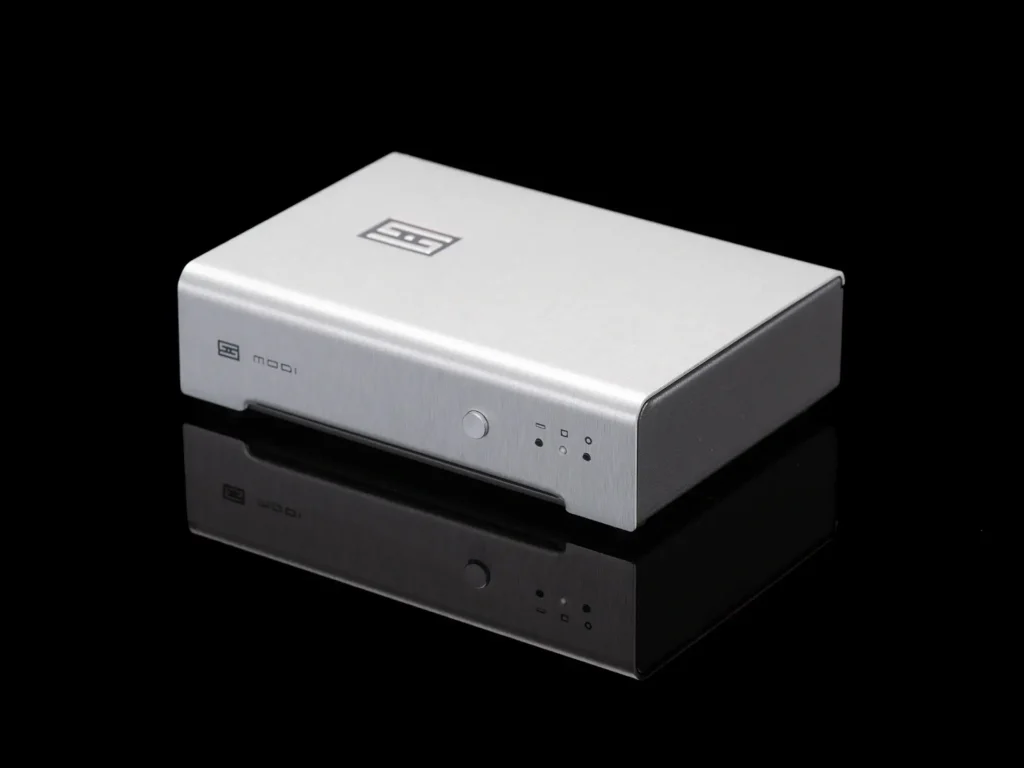 Schiit Modi 3+ DAC, small silver aluminum case with black volume knob and RCA outputs 