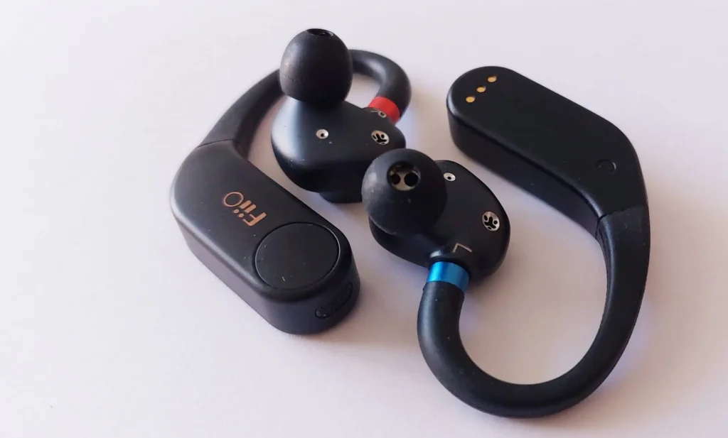 A FiiO UTWS5 review image showing the true wireless ear-hook adapters on a white background. The photo highlights the design, including the red and blue LR markers and gold FiiO logo.