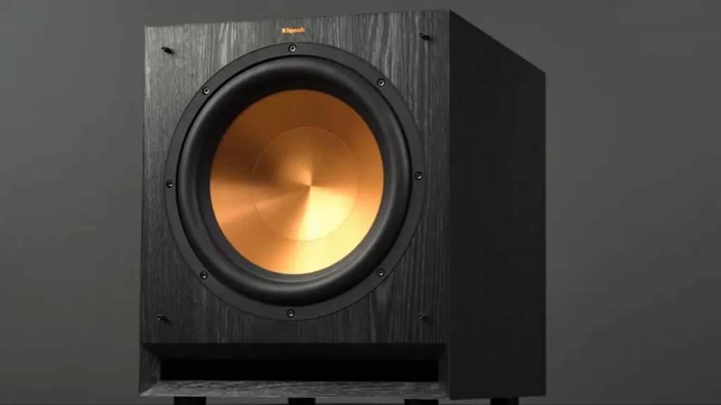 A Closer look of My Klipsch SPL-120 subwoofer with a prominent copper-colored 12-inch driver and a black wood grain finish in my review