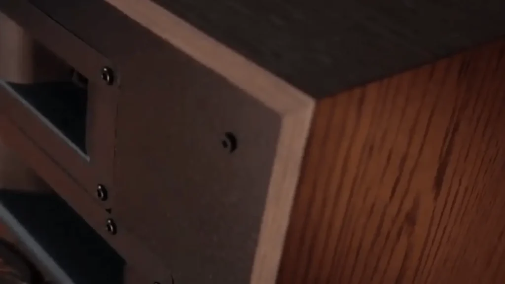 A close-up detail of the Klipsch Heresy IV cabinet craftsmanship, showing the mitered corner and real wood grain.