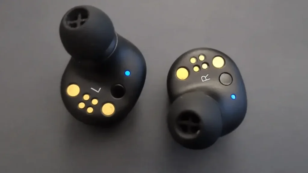 A close-up image of the inner side of my Sennheiser Momentum True Wireless 2 earbuds. The gold charging contacts, the 'L' and 'R' indicators, the ear tips, and the blue LED lights are clearly visible