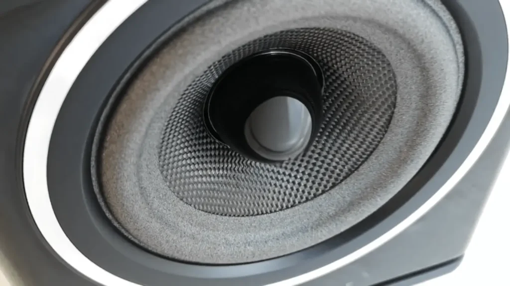 Close-up of the 130mm midbass driver cone on the Wharfedale Diamond 11.1, showing the black woven Kevlar material, the central phase plug, and the new foam surround.