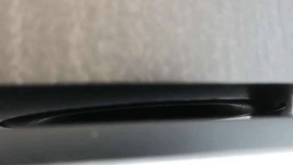 Close-up view of the slot between the bottom of the Wharfedale Diamond 11.1 speaker cabinet and its plinth, which acts as the exit for the down-firing bass reflex port.