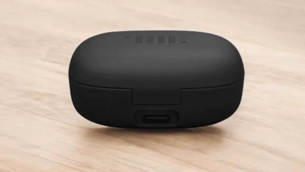 A rear view of the closed matte black charging case of jbl Vibe flex 2. This angle focuses on the sturdy hinge and the USB-C charging port located at the bottom center of the back panel.