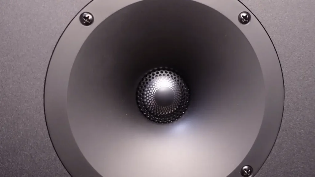 A close-up of the Paradigm Monitor SE 8000F's S-PAL™ dome tweeter, featuring a distinctive black, perforated phase plug with a central dimple and concentric rings
